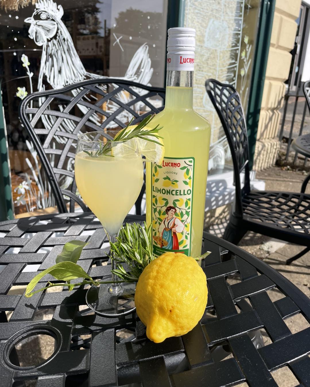 Limoncello cocktail on a sunny pavement table outside the deli